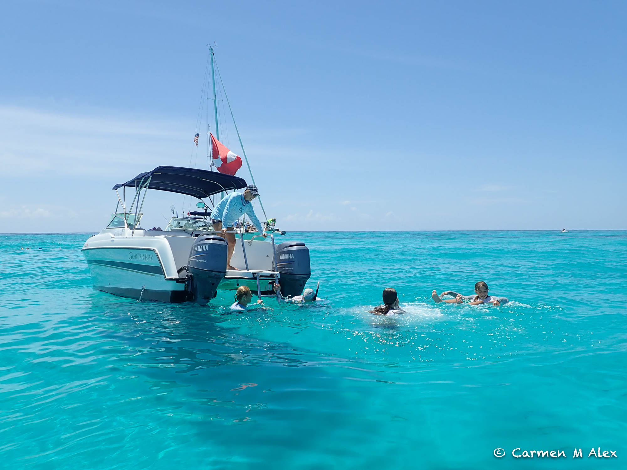 people swimming in front of the catamaran