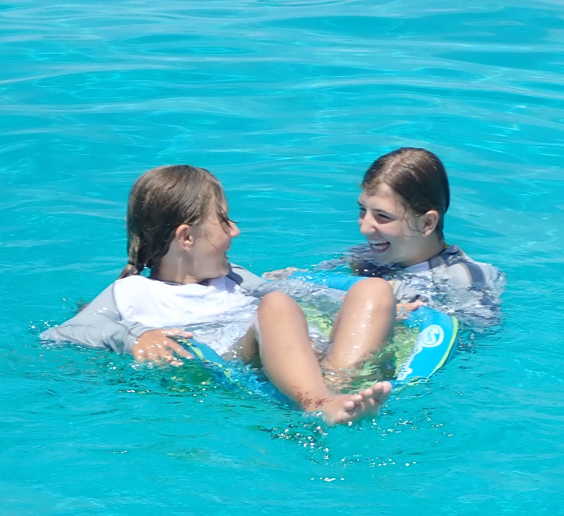 two girls playing in the crystal clear water in the florida keys