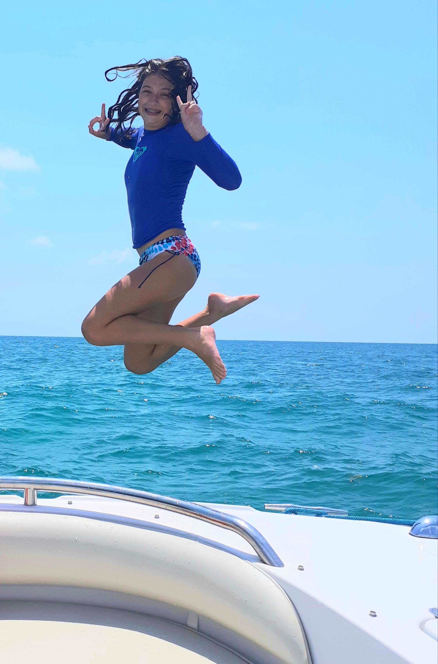 girl jumping into the water from the boat