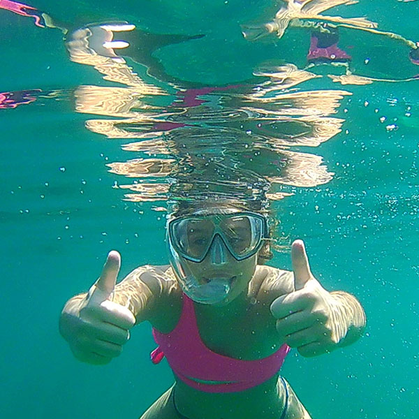 a snorkeler in clear water with mask and snorkel